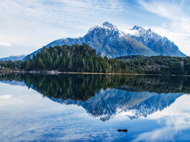 lake near mountain under blue sky during daytime